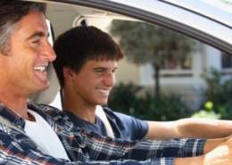 Dad telling car jokes while driving with his son.