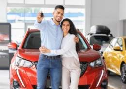 A couple exploring car options at a dealership on the Fourth of July, symbolizing car buying tips.