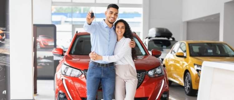 A couple exploring car options at a dealership on the Fourth of July, symbolizing car buying tips.