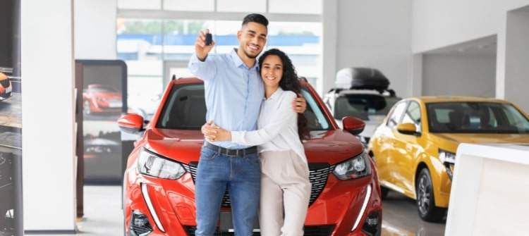 A couple exploring car options at a dealership on the Fourth of July, symbolizing car buying tips.