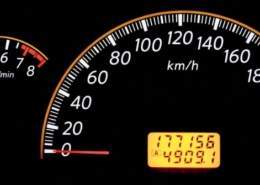 A used car dashboard with high mileage showing on the odometer.