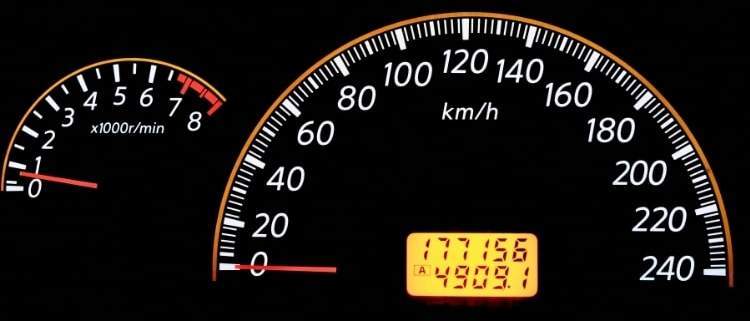 A used car dashboard with high mileage showing on the odometer.