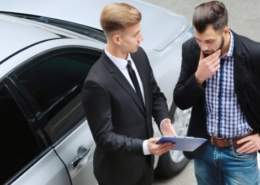 A person negotiating with a car dealer over add-on fees.