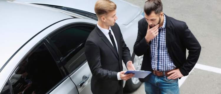 A person negotiating with a car dealer over add-on fees.