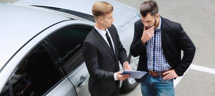 A person negotiating with a car dealer over add-on fees.