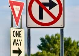 A driver confused by bizarre road signs representing weird traffic laws around the world.