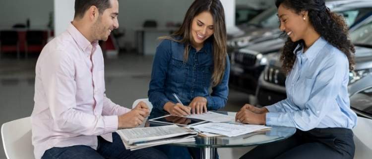 Happy couple buying a car with zero percent financing.