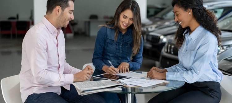 Happy couple buying a car with zero percent financing.